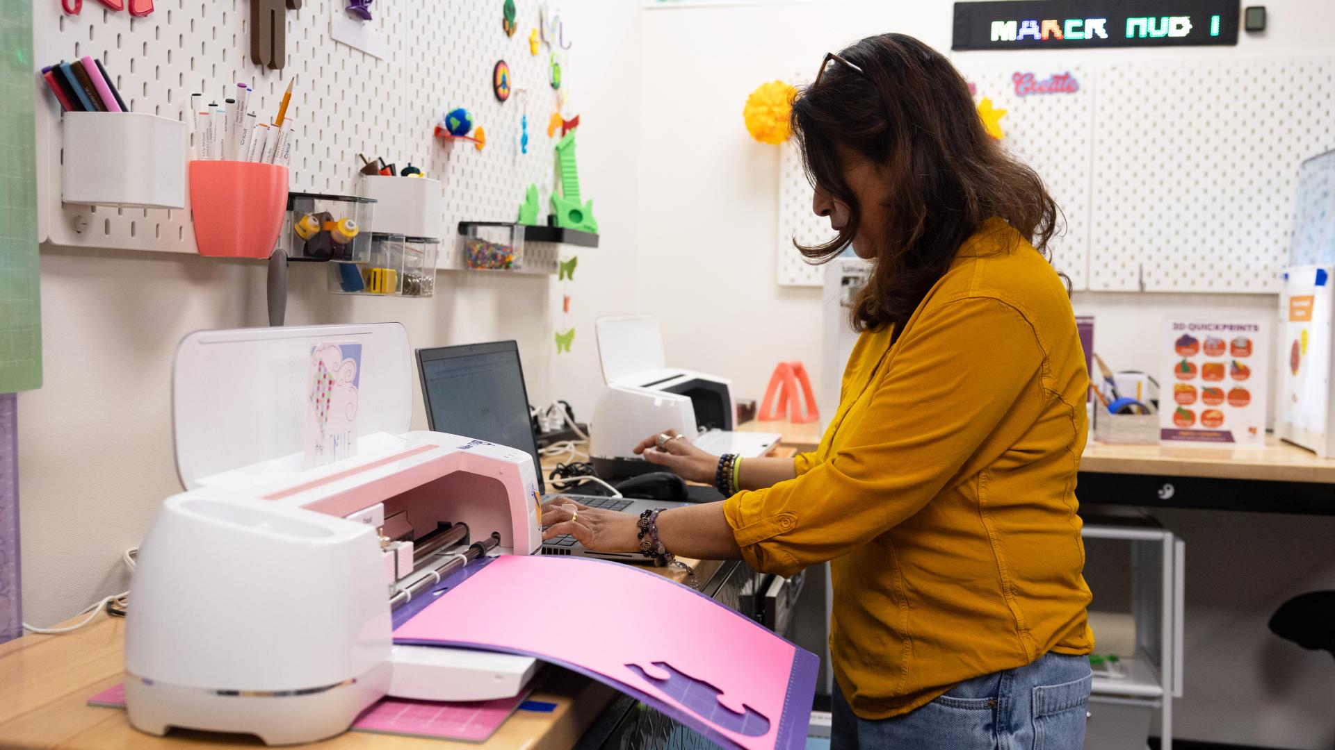 Woman using crafting machines in a workshop.