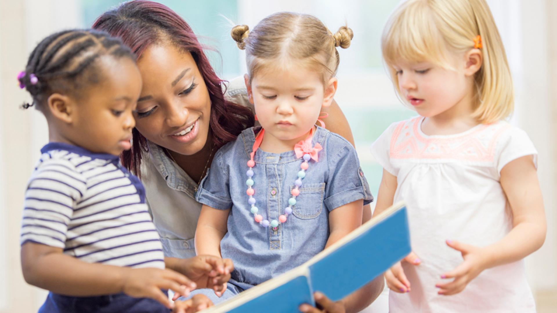 Instructor reading a book with kids