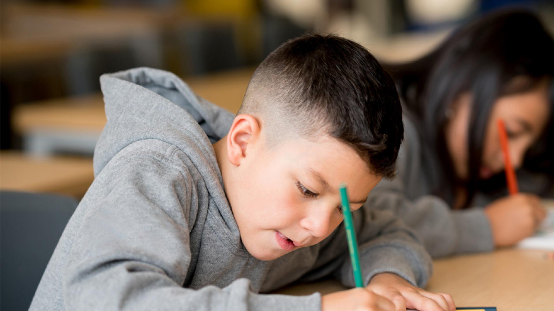 Boy writing in class
